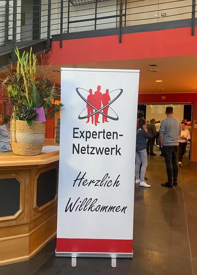 „Herzlich Willkommen“-Aufsteller bei einem Treffen